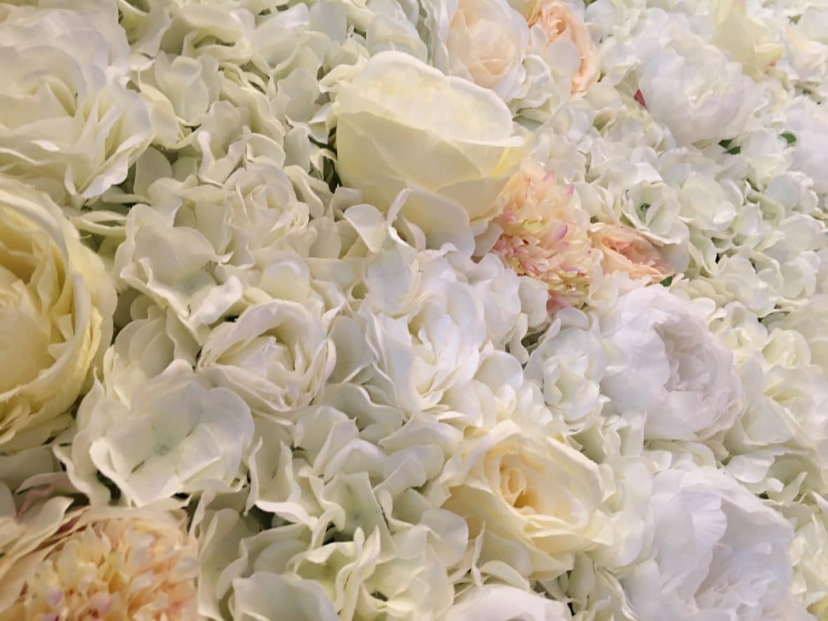 Floralie-Silk flower wall in tones of cream and white with hints of greenery and coral
