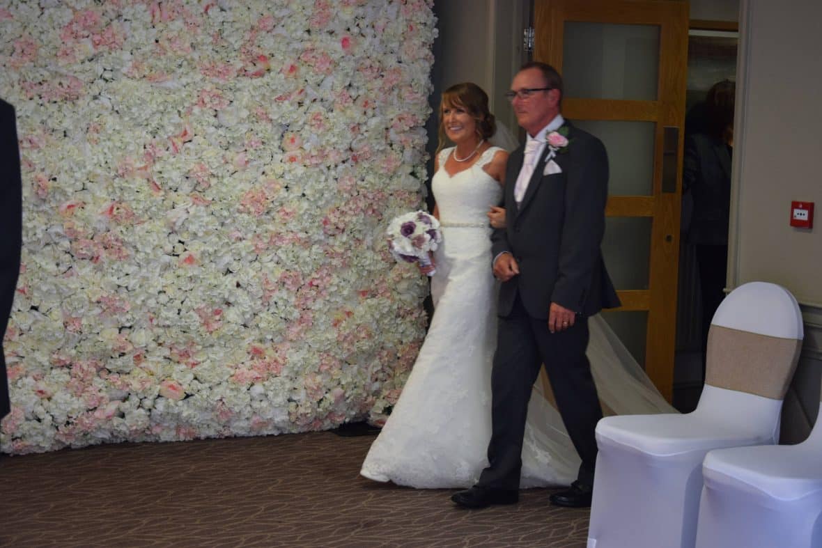 The flower wall was used to create a stunning entrance for the bride and her father.  Accessory Hire from Fabulous Function UK