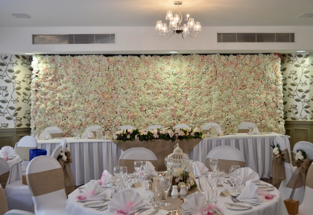 Rustic themed wedding decor with flower wall and bird cage centrepieces