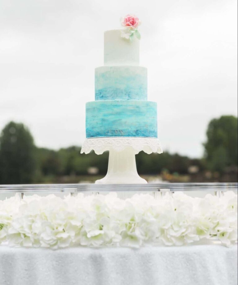 Water colour decorated wedding cake on floating cake table