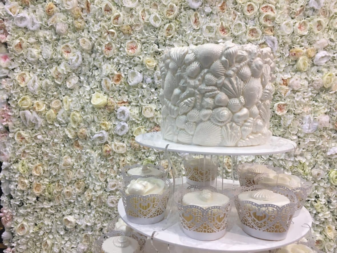Flower wall backdrop to Sea shells decorate the top tier- Fabulous Functions UK