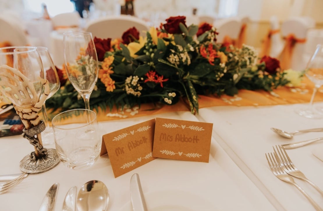 Top table decor in autumn colours perfectly complements the venue styling. Look at the fabulous goblet provided by the bride and groom. Top table decor complements the autumn themed weddingvenue decor