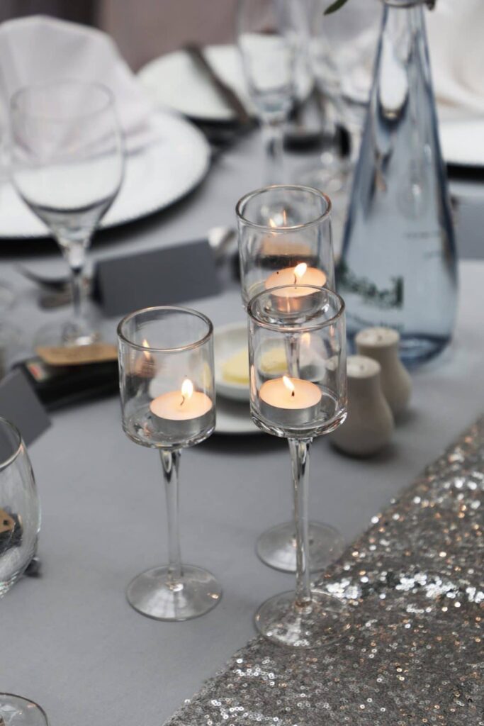 Staggered height glass tea light holders created warmth and brings a soft ambience to the decor - A Silver and Grey Theme 