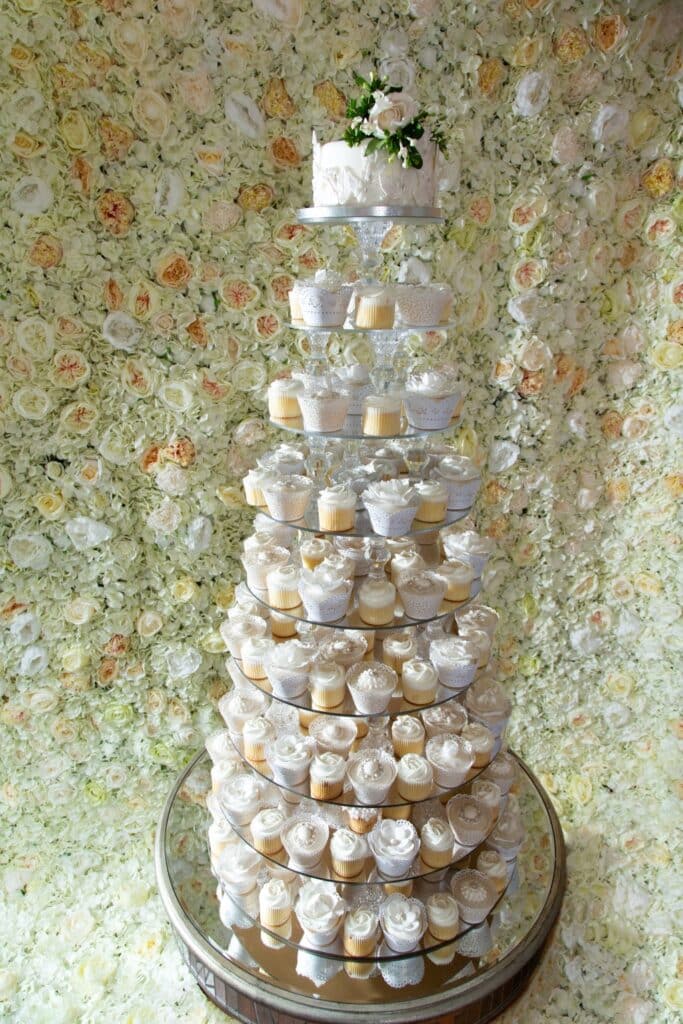 Flower wall with crystal seven tier cake tower in front of it. Photoshoot at the Bear Hotel in Hungerford