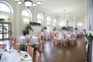 Rose gold wedding theme. The draped backdrop was moved from the ceremony area to become the backdrop for the top table. Styling created by Fabulous Functions UK