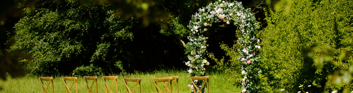 Floral arch backdrop for an outdoor wedding ceremony - Fabulous Functions UK