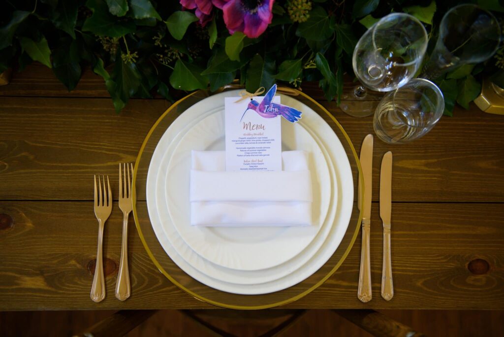 Table setting with hummingbird and lotus themed stationery for a multicultural wedding- Fabulous Functions UK