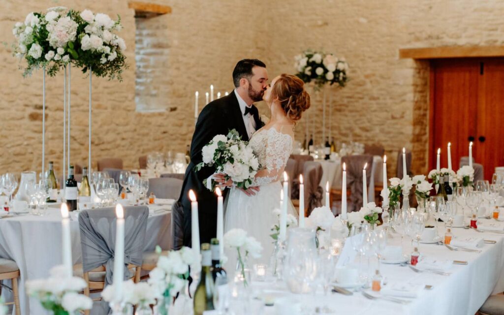 Amy and Jarrad's wedding  at Kingscote Barn- the happy couple!  Surrounded by a beautifully styled wedding decor. romantic silver grey chiffon waterfall ruffles  for their chair decor and a atmospheric candle light. 