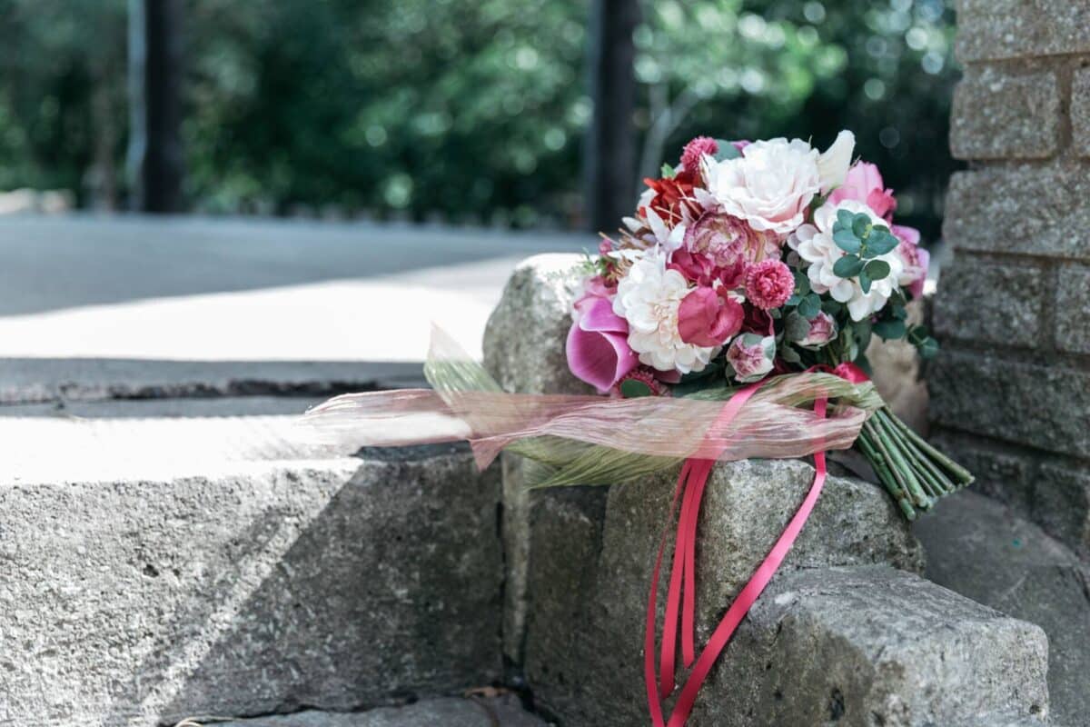 Silk bridal bouquet created with vibrant blooms in hues of fuchsias, burgundys pinks and creams