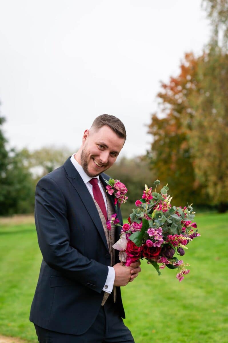 Groom with his brides beautiful silk bouquet at the Pear Tree Purton Wedding Venue